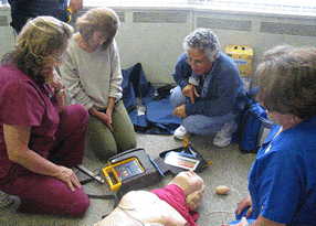 Picture7 four medical professional practicing with a medical equipment on a doll